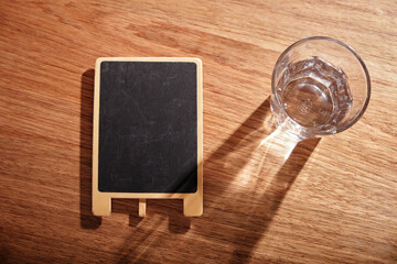 small blackboard and glass of water top view