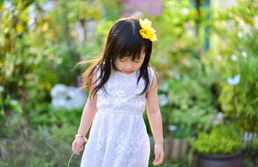 backlight Outdoor portrait of a cute 5 year old Asia little girl 