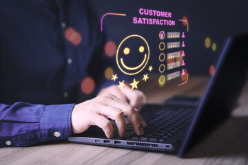 Businessman hand using computer laptop with popup five star icon for feedback review satisfaction service, testimonial. Customer service experience and business satisfaction survey.