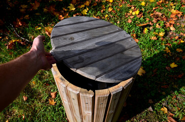 wooden trash park trash can. lined with wood. panelling. cylindrical shape with a bump. natural...