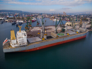 Aerial view of big cargo ship bulk carrier is loaded with coal in port