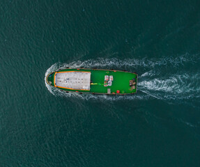 Aerial drone view of industrial tug assisting boat in deep sea