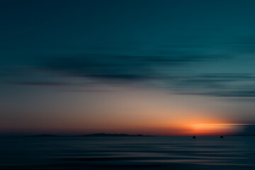 A sunset romantically caressing the silhouette of the island of Elba, admired from two boats...
