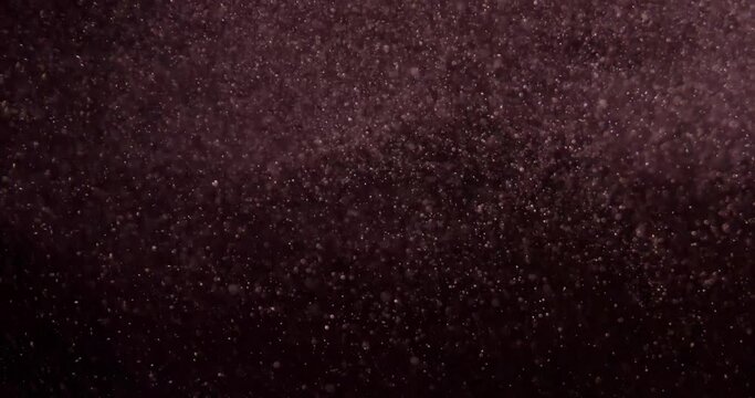 Red particles on black screen slow motion. Filmed with RED camera.