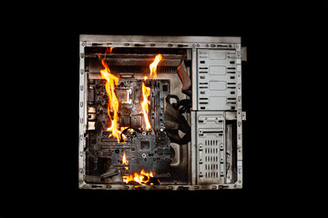 a burning system unit from a computer from a short circuit and a power surge on a black isolated background