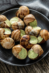 Snails with parsley butter, Bourgogne Escargot Snails on plate. Delikatese food.