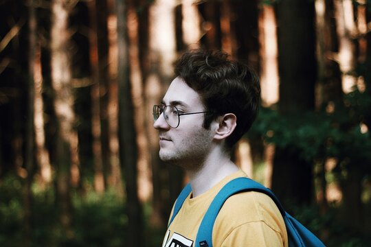 Side View Of Young Man Standing In Forest