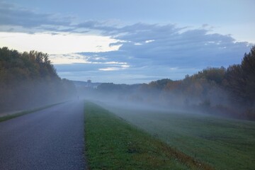 early gloomy morning on bicycle path to the town in autumn