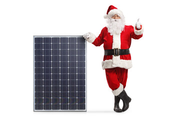 Santa claus leaning on a big solar panel and showing thumbs up