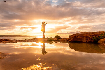 Fototapeta premium Sunset in Ibiza, a young tourist enjoying in San Antonio Abad. Balearic