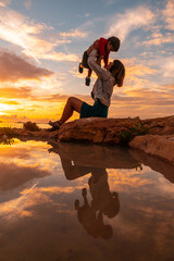 Sunset in Ibiza on vacation, a mother with her son having fun by the sea in San Antonio Abad