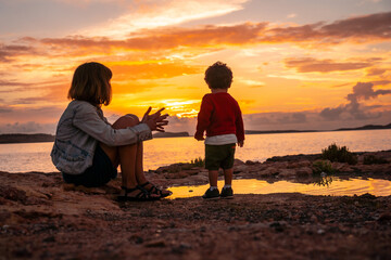 Mother with her son on the promenade at sunset in San Antonio Abad, Ibiza Island