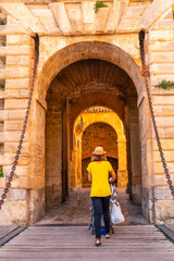 A young woman on vacation at the entrance of the coastal Ibiza town wall, Balearic Islands, Eivissa