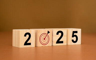Business planning in 2025. Wooden cubes with the letters 2025 on a table with a brown background - obrazy, fototapety, plakaty