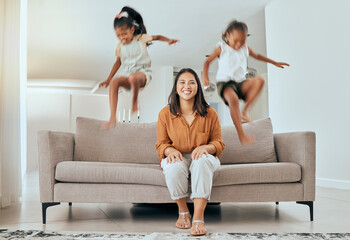 Family, mom and kids jumping on sofa having fun, energetic and hyper at home. Happiness, joy and...