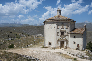Fototapeta premium The church of Santa Maria della Pietà in Rocca Calascio with the beautiful Abruzzo mountains and hills in the background