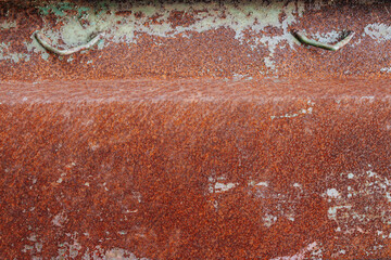 Corner of a rusted metal box. Orange degraded dented texture