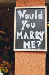 Marriage proposal written on a blackboard sign, outside a flower shop in San Francisco, California