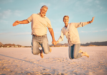 Couple, beach and active seniors hold hands while jumping in sand, happy and excited at sunset. Love, family and freedom with mature man and woman jump in celebration of retirement, travel and energy - Powered by Adobe
