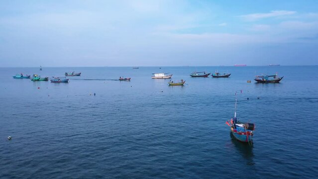 Fishing boats anchored in front of the marina in Vung Tau iin early morning light. A long right to left aerial tracking shot showing many different types of boats.