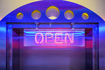 Neon light color blue Open sign on a door for business front of shop.