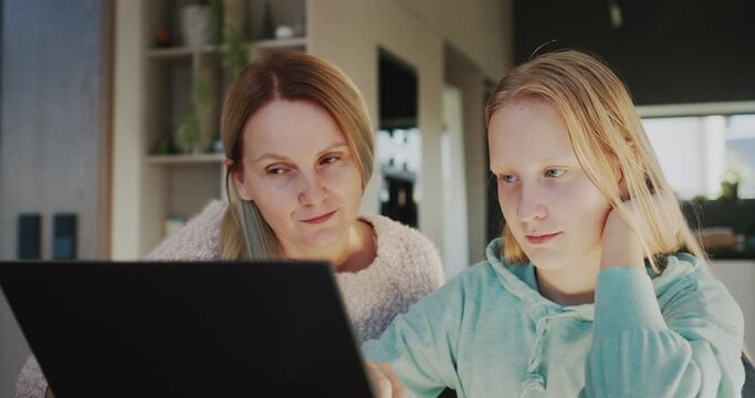 Mom and daughter use laptop together. Homeschooling concept