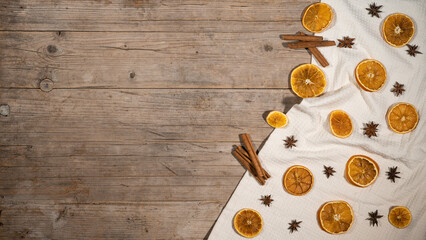christmas winter food advent background - christmas scent, dried orange slices, cinnamon sticks and cloves, on rustic wooden table, top view