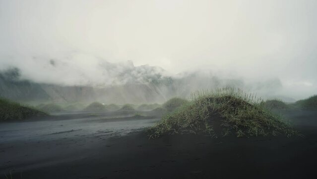 Slow panning shot of the misty early morning at mysterious Stokksnes beach in Iceland in 4k