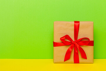 holiday brown paper present tied red ribbon bow top view with copy space. Flat lay holiday background. Birthday or christmas present. Christmas gift box concept with copy space