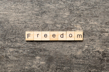 Freedom word written on wood block. Freedom text on cement table for your desing, Top view concept