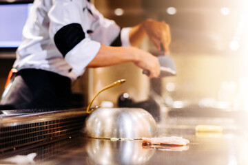 Hand of man take cooking of meat with vegetable grill, Chef cooking wagyu beef in Japanese teppanyaki restaurant