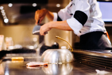 Hand of man take cooking of meat with vegetable grill, Chef cooking wagyu beef in Japanese teppanyaki restaurant