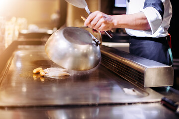 Hand of man take cooking of meat with vegetable grill, Chef cooking wagyu beef in Japanese teppanyaki restaurant