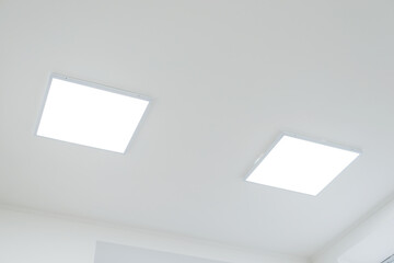 Two panels of LED light on white ceiling. LED light in office