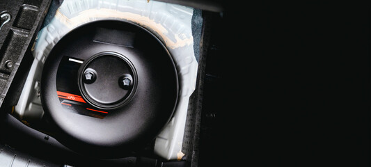 LPG black tank in the shape of a donut in a spare wheel hole in the trunk of a car