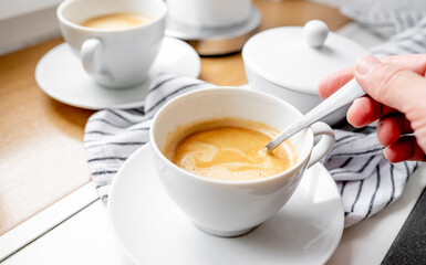 Girl stirs sugar in a cup of coffee