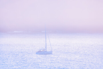 Fototapeta premium Silhouette of a sailboat in the fog in San Francisco Bay, California, USA