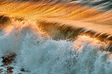 Sea wave and golden sunset reflection, Pacific Ocean, California, USA, close-up. Beautiful scenery and background