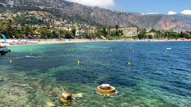 Walking In The Promenade Of Plage des fourmis With Panorama Of Blue Sea and Beachfront Resort In Beaulieu-sur-Mer, France. - POV