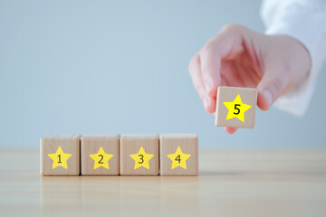 Evaluation, Satisfaction, Feedback, Review concept. Hand holding star with 5 number on wooden block with Excellent on speech bubble. The best excellent business services rating customer experience.