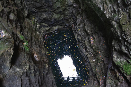 view of the sky through a deep granite underground well