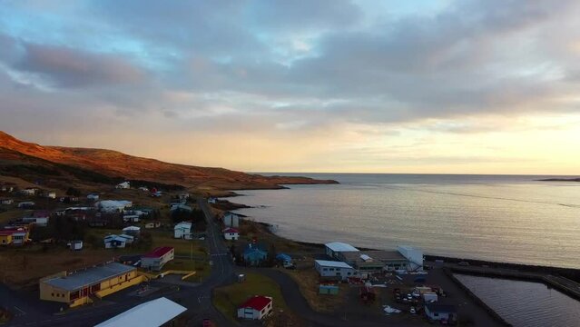 sunset in a fishing village over an Icelandic fjord in winter, aerial drone images of a magical and unique place