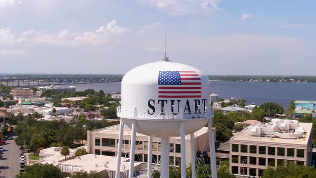 Aerial parallax orbiting round water tank in city Stuart, Florida