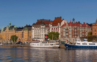 Fototapeta na wymiar Tourists, offices, apartment and hotel buildings, old steam and modern boats a colorful autumn day in Stockholm