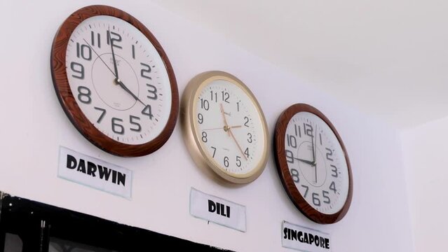 World clocks on wall with time zones from Dili Timor Leste, Darwin Australia and Singapore