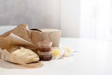 Fast food in craft packaging on white table
