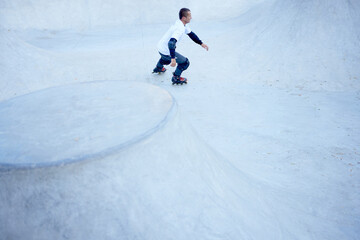 Mature male inline roller training in public skate park. Practicing jumps, tricks. Concept of...