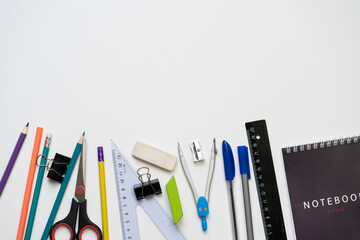 top view layout of some different school supplies on pastel background