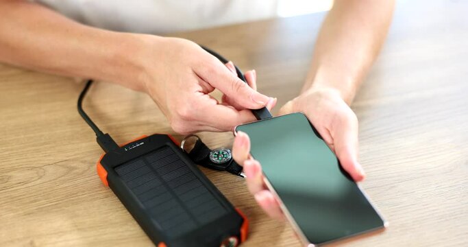 Power bank on solar batteries charges smartphone via usb cable