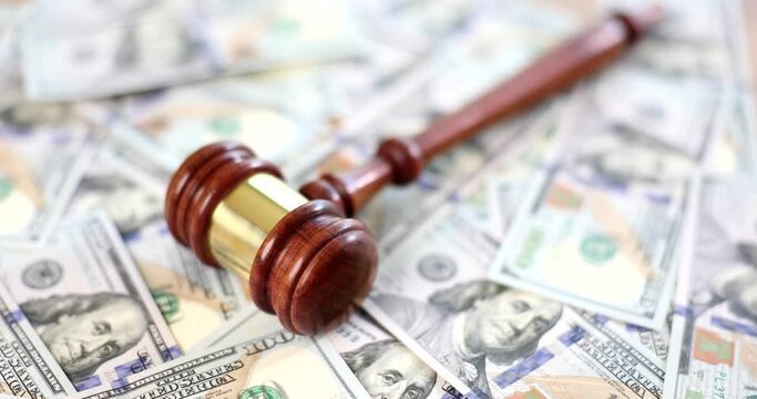 Judge or auctioneer gavel on background of cash dollars top view closeup